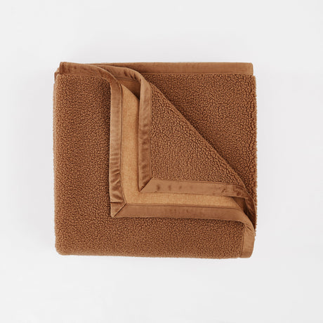 Folded brown blanket on a white background