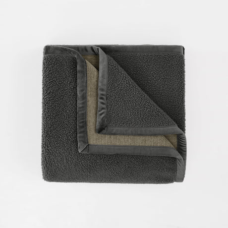 Folded dark gray fleece blanket on a white background