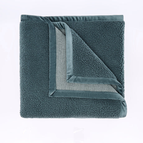 Folded gray fleece blanket on a light purple background
