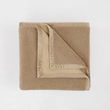Folded beige towel on a white background