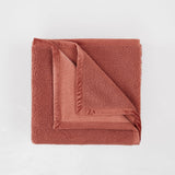 Folded brown towel on a light gray background
