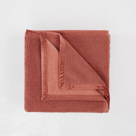 Folded brown towel on a light gray background