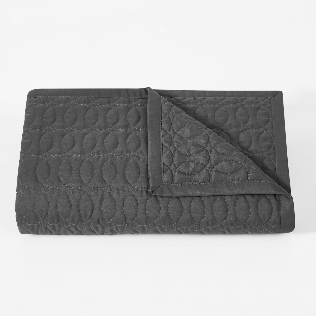 Dark gray quilted blanket on a white background