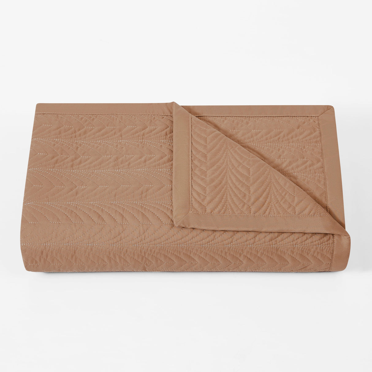 Folded brown quilt on a white background