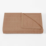 Folded brown quilt on a white background