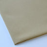 Pictured: Close-up of a neatly folded tablecloth against a white background. This tablecloth is in the shade Sandalwood.