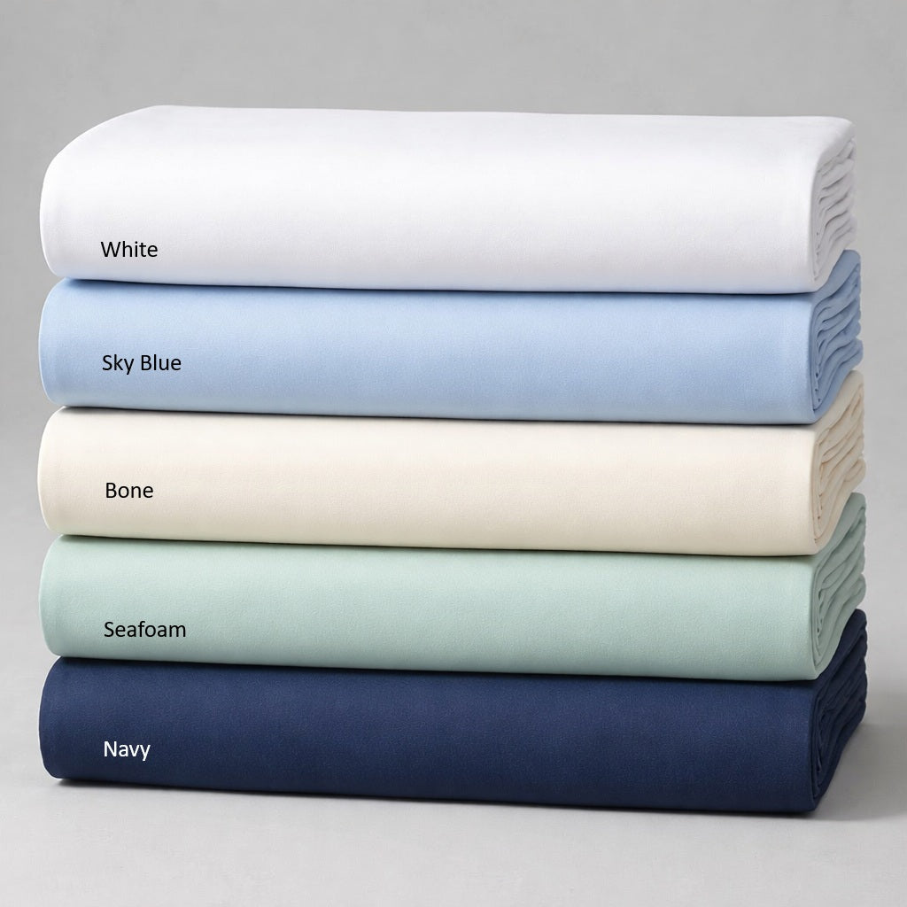 Stack of folded sheets in white, sky blue, bone, seafoam, and navy on a gray background.