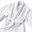 Pictured: White spa robe against a white background. This robe is the Microfiber Classic Shawl Collar Bathrobe. The inside of the robe and the collar are a fluffier material for maximum comfort.