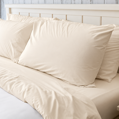 Pictured: Bone colored bedding on a white bed frame. The blanket is white, and has a bone top sheet, fitted sheet and pillowcases.