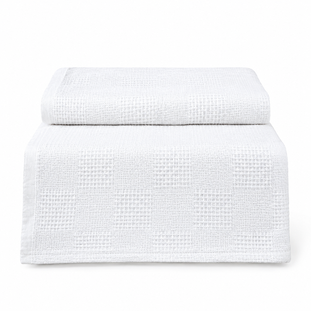 Pictured: White Healthcare Cotton Thermal Blanket folded at the top with the bottom half draped over an object against a white background.