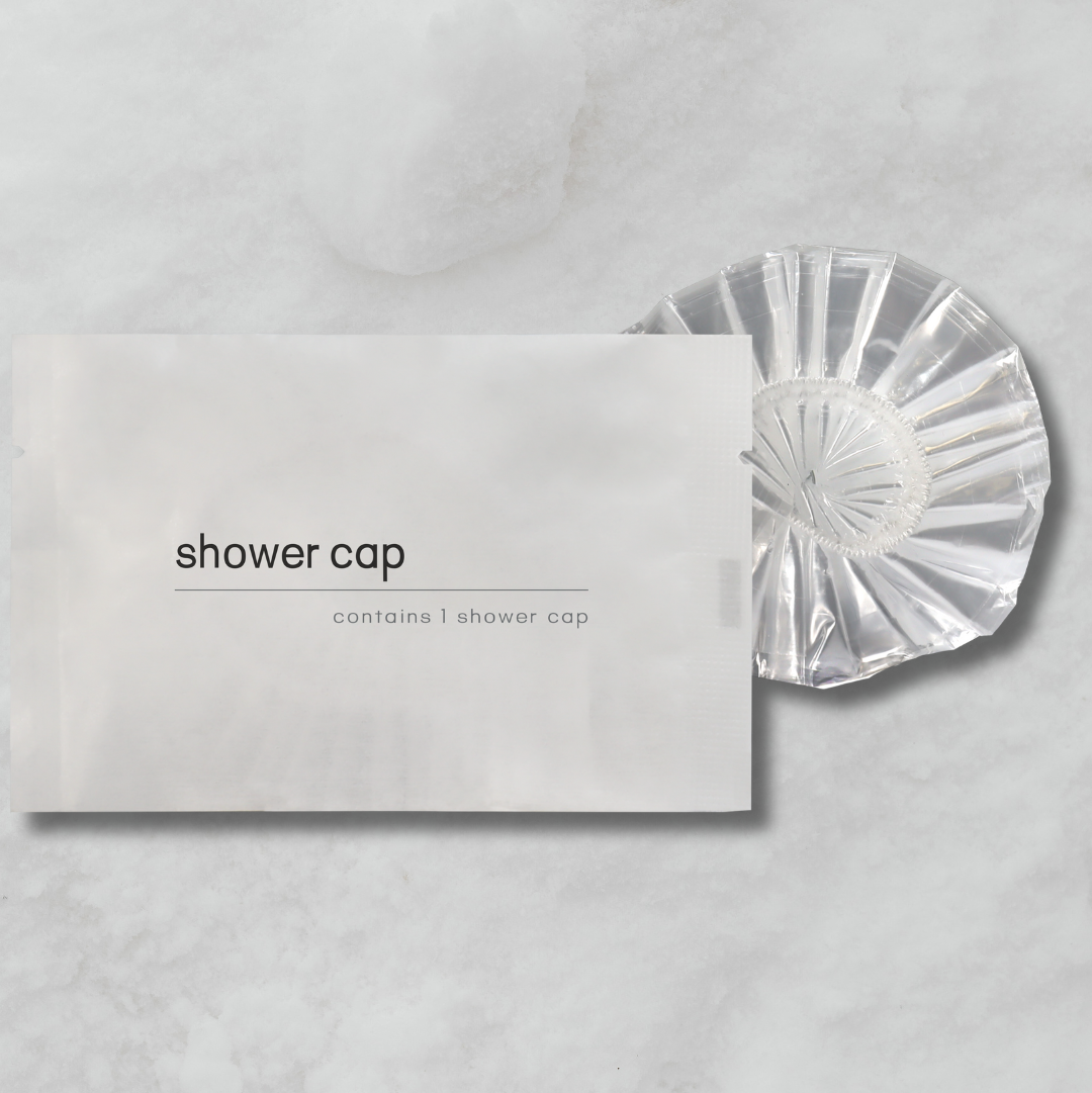 Clear shower cap on a gray background with packaging labeled 'shower cap'.