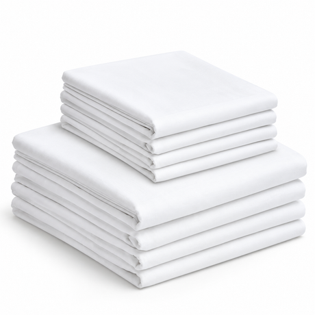 Pictured: Neatly folded white Economy Sheets stacked on top of each other. There are 4 larger sheets on the bottom and 4 smaller sheets stacked on top.