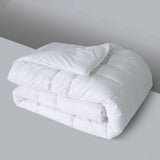Folded white comforter on a gray surface