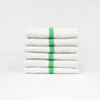 Pictured: Six white bar mops with a green center stripe neatly folded and stacked against a white background.