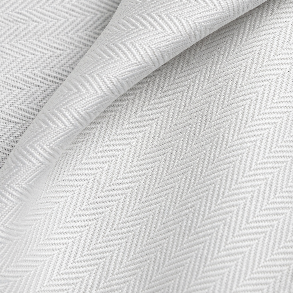 Pictured: Extreme closeup of the white fabric and herringbone pattern of the top sheet.