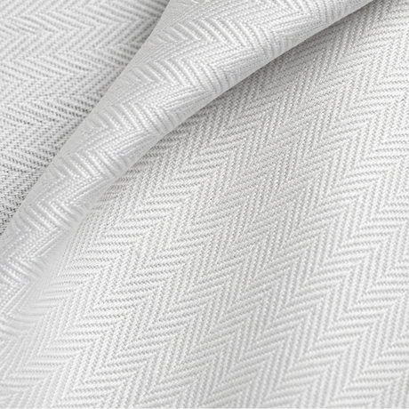 Pictured: Extreme closeup of the white fabric and herringbone pattern of the top sheet.