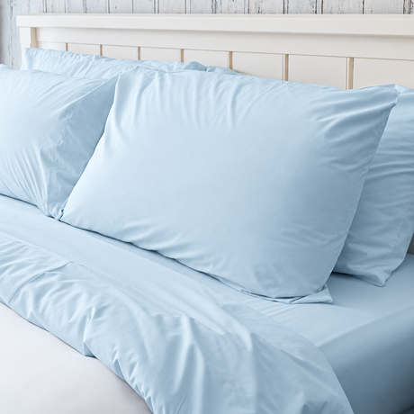 Pictured: Blue bedding on a white bed frame. The blanket is white, and has a blue top sheet, fitted sheet and pillowcases.