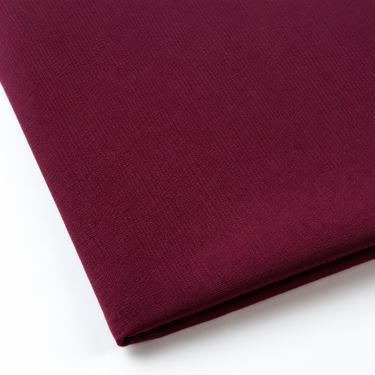 Pictured: Close-up of a neatly folded tablecloth against a white background. This tablecloth is in the shade Maroon.