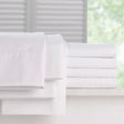 Pictured: Full Millennium t-200 Sheets, neatly folded and stacked atop a white counter in front of a window. The items you can get are the fitted sheet, the flat sheet and the pillowcases.
