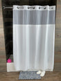 White roller blind on a wooden window frame with a textured wall background