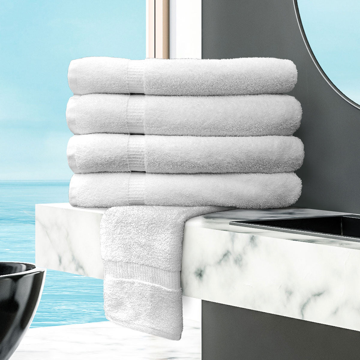 Stack of white towels on a marble countertop with a blue wall background
