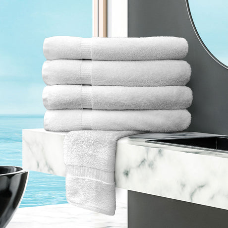 Stack of white towels on a marble countertop with a blue wall background