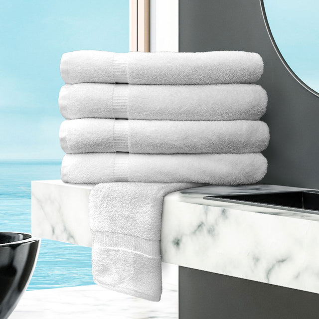 Stack of white towels on a marble countertop with a blue wall background