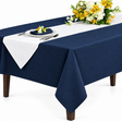 Pictured: 54x54 Permalux Tablecloth in the shade Flag Blue draped over a table with flowers, silverware, and a white plate.