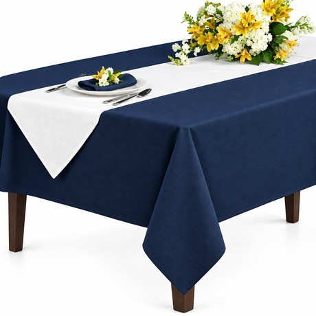 Pictured: 54x54 Permalux Tablecloth in the shade Flag Blue draped over a table with flowers, silverware, and a white plate.