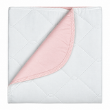 Pictured: Green and pink underpad for incontinence against a white background. The pad is neatly folded and has a corner folded over to show what the pink bottom of the pad looks like.