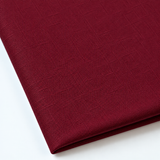 Pictured: Close up of the Premier Napkin neatly folded in the shade Burgundy against a white background.