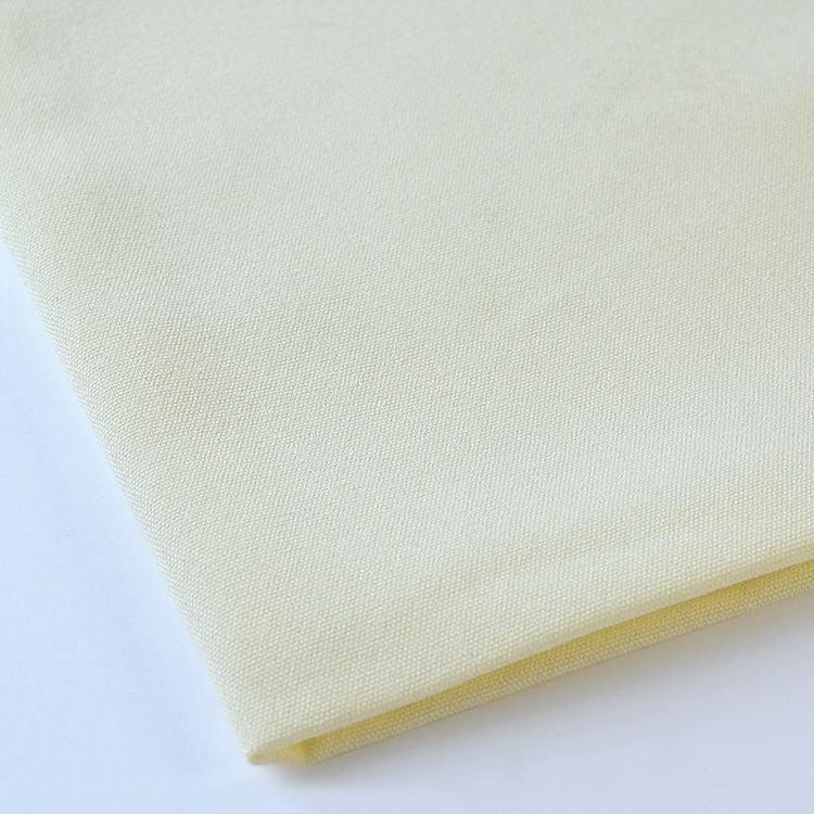 Pictured: Close up of the Premier Napkin neatly folded in the shade Ivory against a white background.