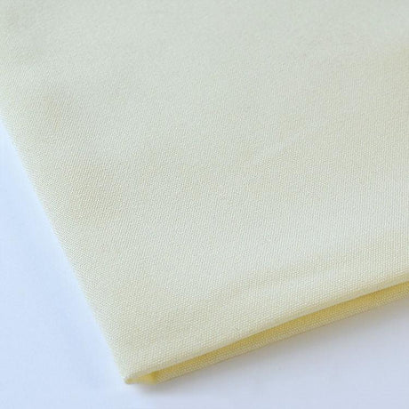 Pictured: Close up of the Premier Napkin neatly folded in the shade Ivory against a white background.