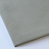 Pictured: Close up of the Premier Napkin neatly folded in the shade Light Olive against a white background.