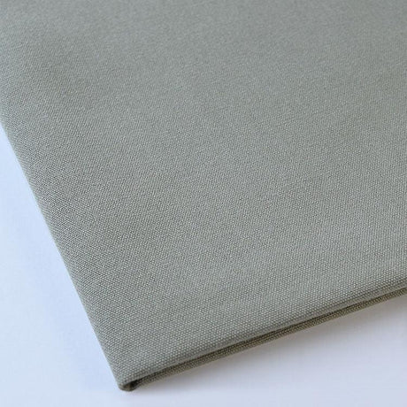Pictured: Close up of the Premier Napkin neatly folded in the shade Light Olive against a white background.