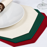 Pictured: Three of the premier placemats spread on a white table with a plate on top and a wine glass in the top left corner. 