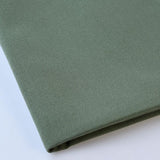 Pictured: Close up of the Premier Napkin neatly folded in the shade Sage against a white background.