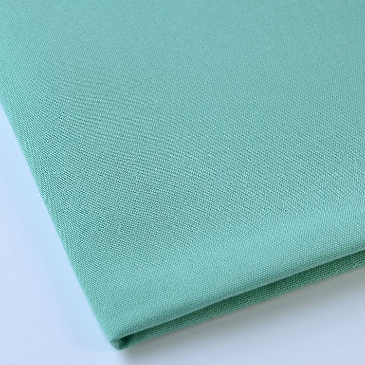 Pictured: Close up of the Premier Napkin neatly folded in the shade Seafoam Green against a white background.