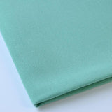 Pictured: Close up of the Premier Napkin neatly folded in the shade Seafoam Green against a white background.