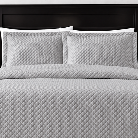 Pictured: Grey bedding on a dark wood bedframe. The bedding features the Radiance Diamond Quilted Sham, which has a diamond stitch creating a textured pattern.
