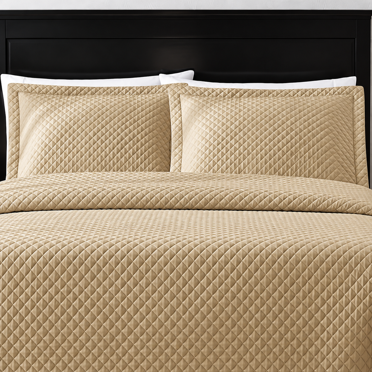 Pictured: Tan bedding on a dark wood bedframe. The bedding features the Radiance Diamond Quilted Sham, which has a diamond stitch creating a textured pattern.