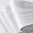 Pictured: Three white checkered sheets neatly folded and stacked on top of each other against a white background.