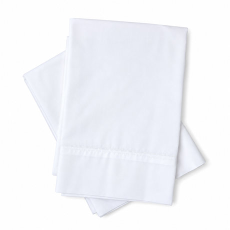 Pictured: Two neatly folded white sheets laid on top of each other against a white background. These pillows have the Royal Suite T-300 Pillowcase on them.