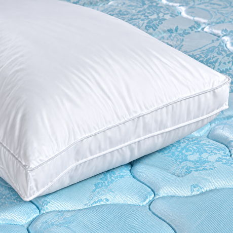 Pictured: Cuboid white pillow laying atop a blue mattress.