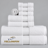 Pictured: White towels with a cam border in the center. The towels are neatly folded and stacked according to size. In the bottom left corner is the YELLOWFIN logo.